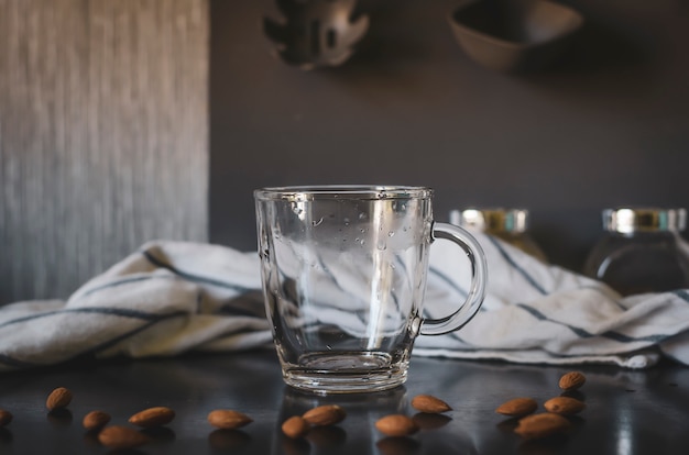 Mug vide en verre avec amandes autour