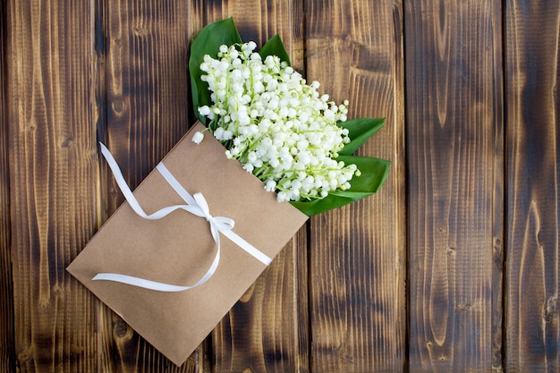 Muguet dans une enveloppe attachée avec un ruban vert