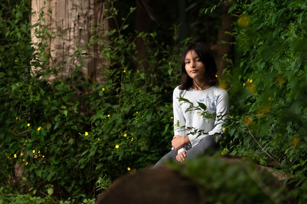 Mujer sentada en bosque encantado