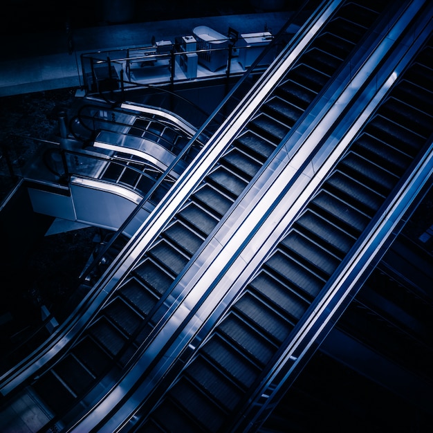 Les multiples étapes et les directions d&#39;un escalator dans le centre commercial moderne, fond noir et blanc