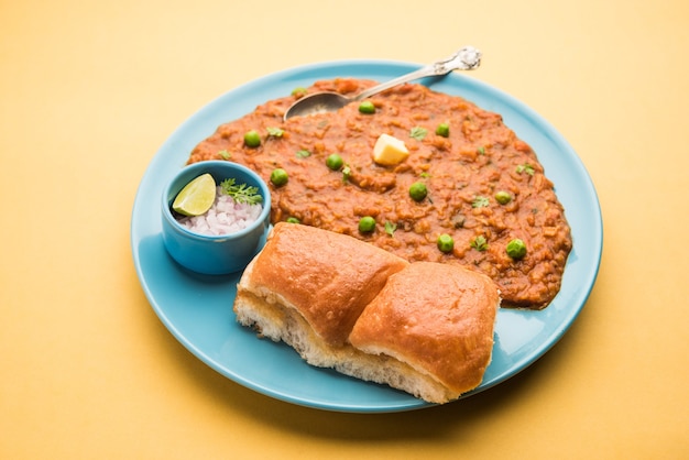 Mumbai Style Pav bhaji est un plat de restauration rapide de l'Inde, se compose d'un curry de légumes épais servi avec un petit pain moelleux, servi dans une assiette