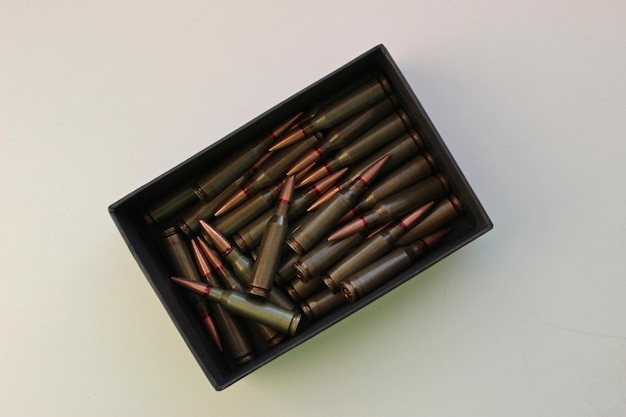 Munitions réelles dans une boîte noire éparpillées isolé sur blanc Stock Photo