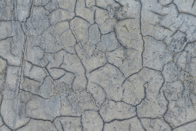 Mur de béton fissuré en gris