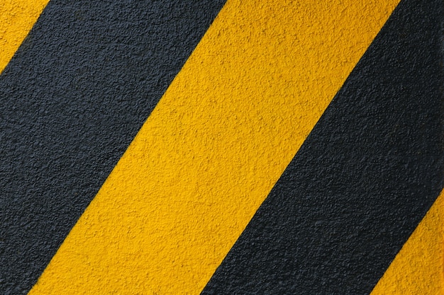 mur de béton avec fond de rayures diagonales jaunes et noires