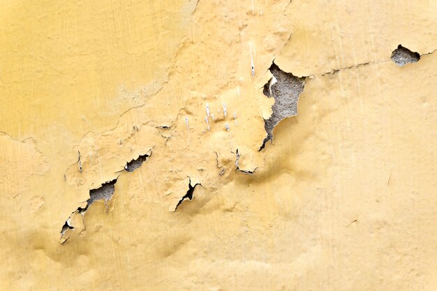 mur de béton peint érode jaune, fond de texture rugueuse grunge
