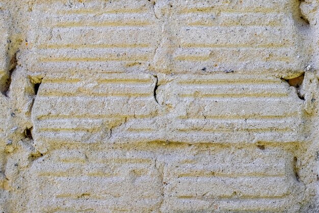 Mur en béton avec rayures verticales provenant de carreaux de parement démontés