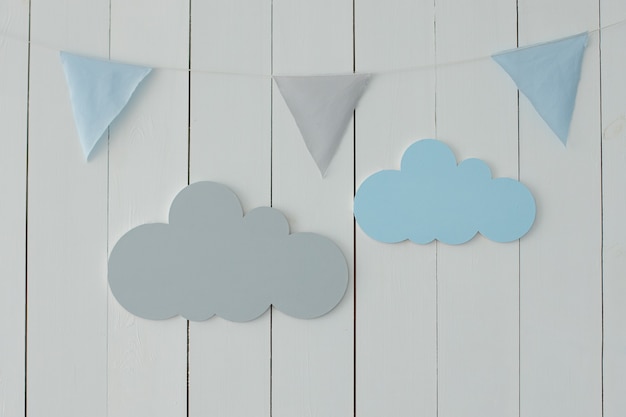 Le mur blanc est décoré de guirlandes de drapeaux et de nuages décoratifs Décor pour les vacances Chambre d'enfants élégante avec drapeaux suspendus Décoration pour chambre de bébé