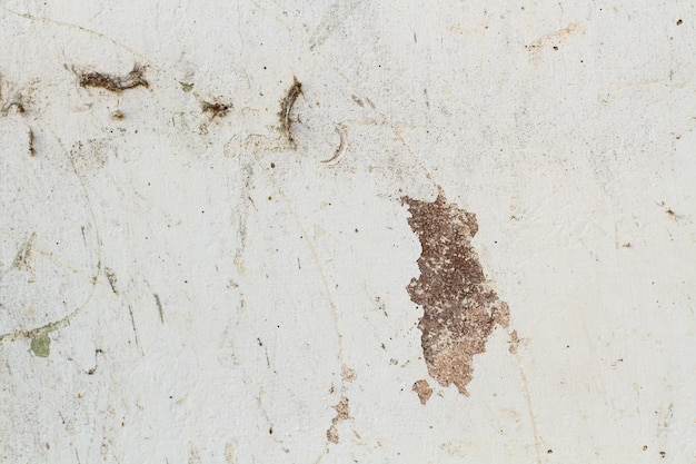 Un mur blanc rayé et cassé dans une vue rapprochée