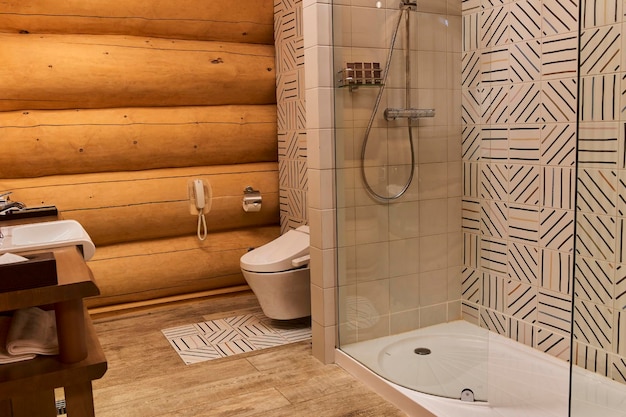 Mur en bois dans la douche et carrelage gris dans la nouvelle salle de bain