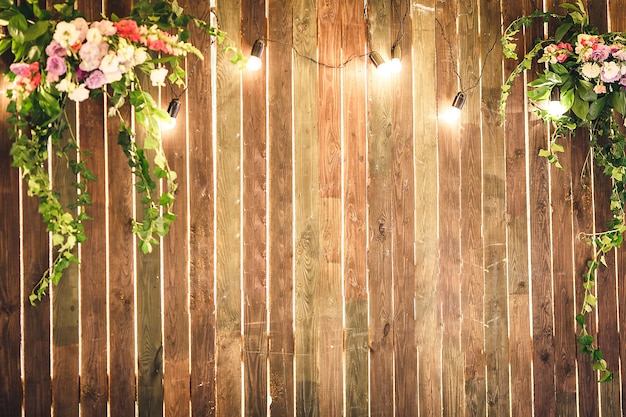 Mur en bois avec lampes et fleurs