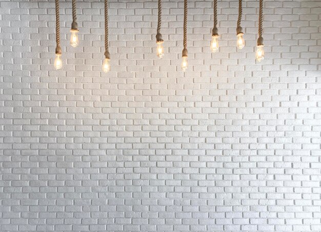 Photo un mur de briques blanches avec des ampoules en verre en feu
