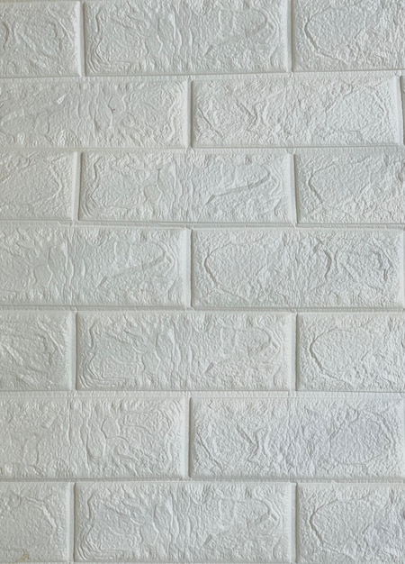 Un mur de briques blanches avec un motif de lignes et de lettres.