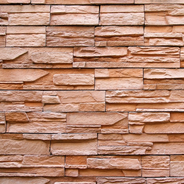 Mur de briques brunes ou texture et fond de mur de pierre