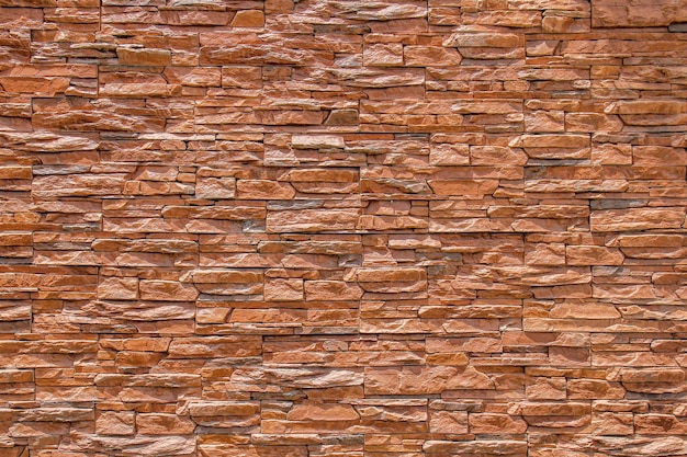 Mur de briques brunes ou texture et fond de mur de pierre