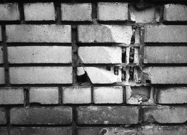 Mur de briques fissuré noir et blanc