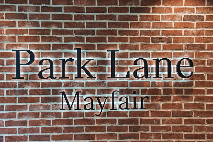 Photo mur en briques avec le panneau park lane mayfair à londres, au royaume-uni