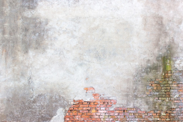 Photo mur de briques avec plâtre endommagé, surface de ciment brisé en arrière-plan