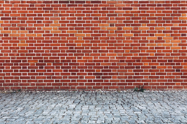 Mur de briques rouges rétro et pavés pavés.