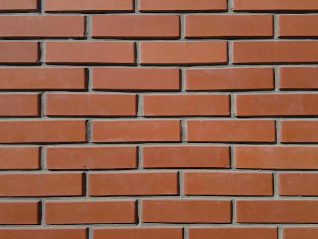 Mur de briques rouges rugueux avec des morceaux de ciment