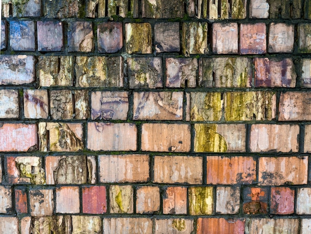 Photo mur de briques en ruine du bâtiment dans des endroits recouverts de mousse et d'éléments d'érosion arrière-plan horizontal photo de haute qualité