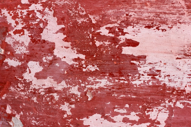 mur de ciment avec de la peinture rouge, fond rugueux. Abstrait béton avec de la vieille peinture rouge écaillée.