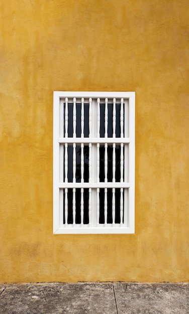 Mur coloré jaune avec une fenêtre blanche dans la maison des Caraïbes