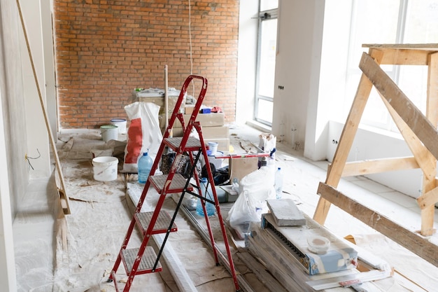 Le mur du bâtiment est recouvert de plâtre frais et entouré de construction. Arrière plan.