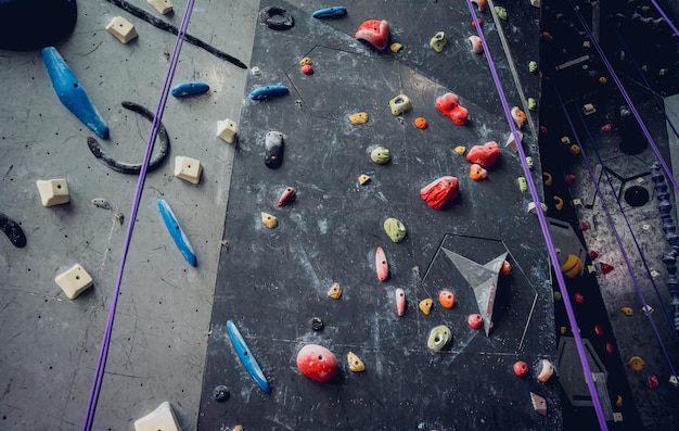 Mur d'escalade artificiel avec des poignées et des cordes colorées