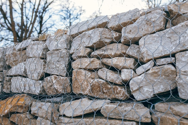 Mur de gabions en pierre le long de la route goudronnée en hiver