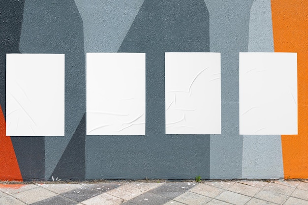 Mur géométrique et quatre modèles d'affiches ridées collées en blanc