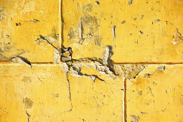 Mur jaune avec rayures et éclats.