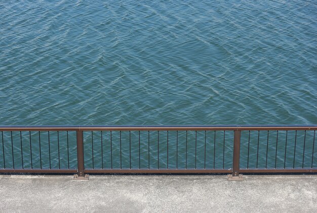 Mur de marche avec clôture en acier près du fleuve.