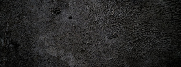 Mur noir effrayant ou fond de texture de pierre granuleuse rugueuse gris foncé Béton noir pour le fond