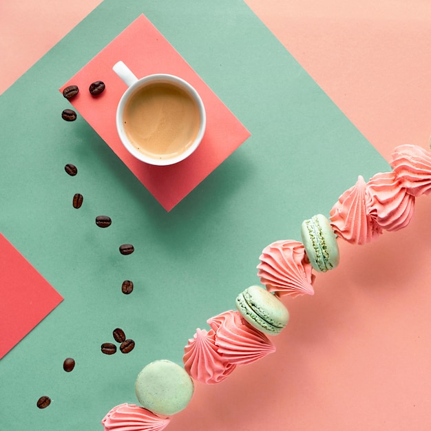 Mur de papier géométrique aux couleurs menthe et corail avec café et bonbons