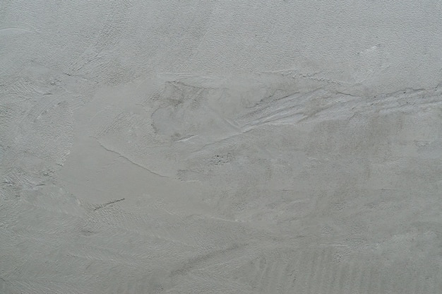 Mur de parement inachevé avec d'étranges rayures dans la maison ou la résidence mur cimenté gris utilisé comme texture d'arrière-plan