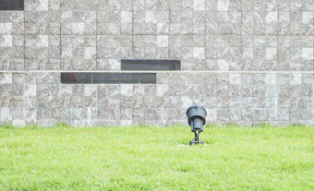 Mur de pierre brique avec texture d&#39;herbe verte