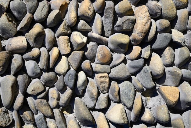 Mur de pierre de fond et de texture de galets de mer lisses