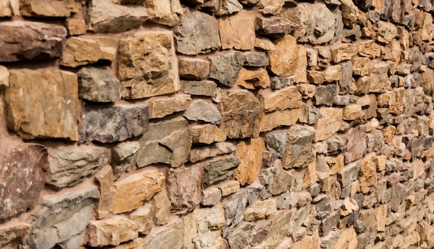 Mur de pierre irrégulière rouge, orange