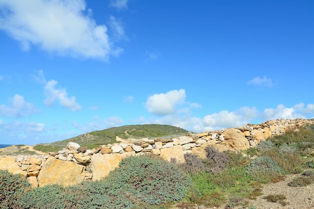 Mur en pierre sèche sous un ciel nuageux en Sardaigne