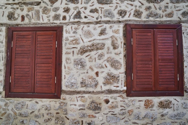 Mur de pierre et vieilles fenêtres en bois