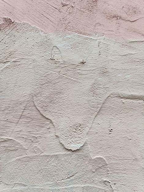 Mur plâtré rose avec des traces de peinture rose beau fond