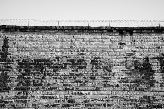 Photo mur de prison abandonné en briques et en pierre