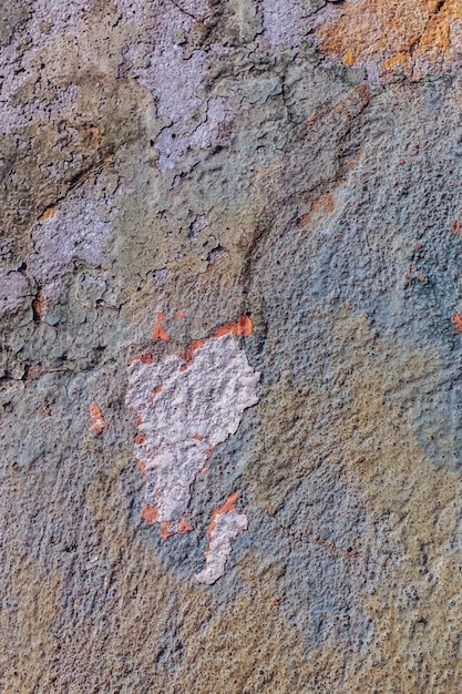 Mur texturé en béton avec peinture écaillée.