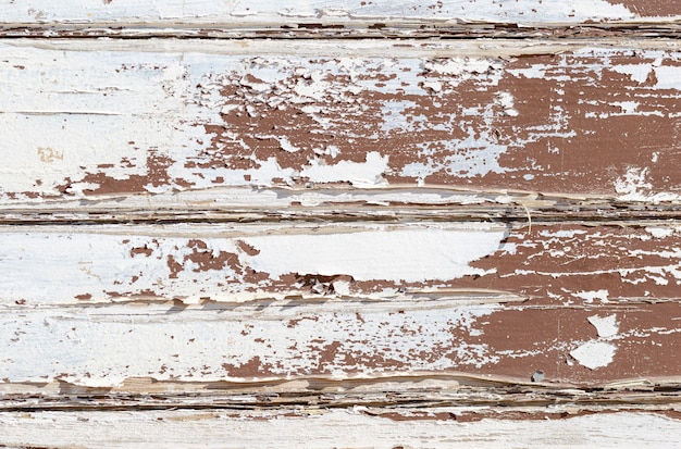 Mur de texture en bois grunge avec de la peinture blanche qui se décolle sévèrement