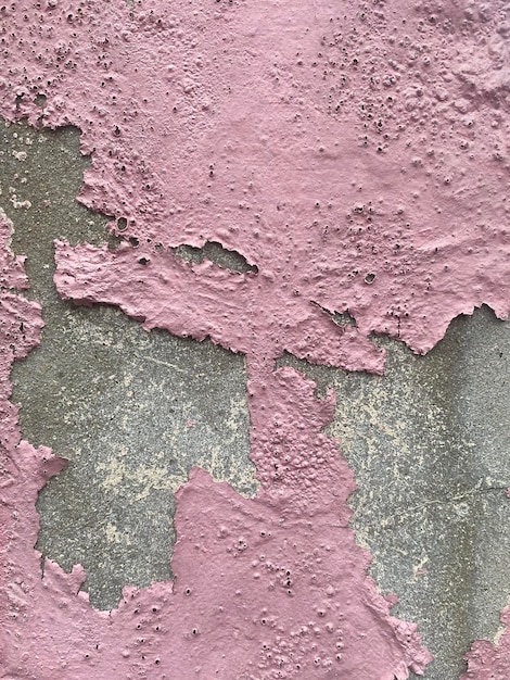 Un mur texturé rose avec une surface texturée rugueuse.