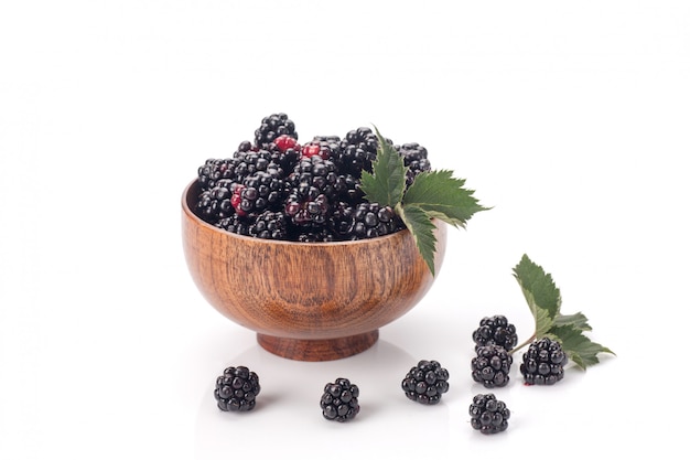 Mûres dans un arc en bois. Fruits noirs mûrs et savoureux isolés sur blanc.