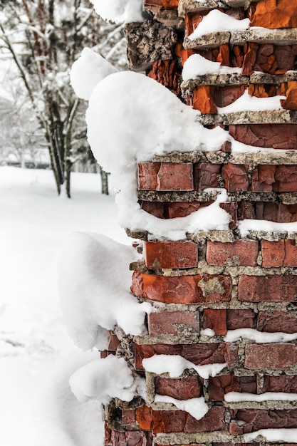 Murs de briques glacées vieux et cassés dans la neige et la glace