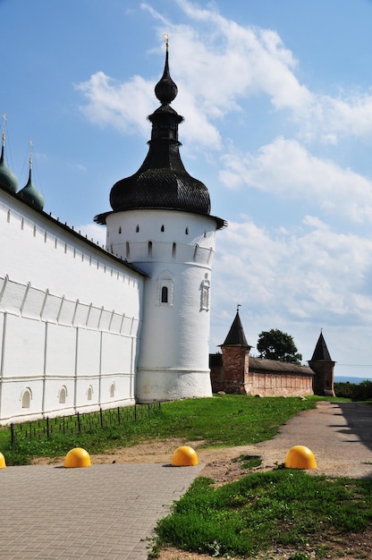 Les murs du Rostov Kremlin avec des tours. Un haut mur blanc avec une tour et un mur avec deux tours en briques rouges.