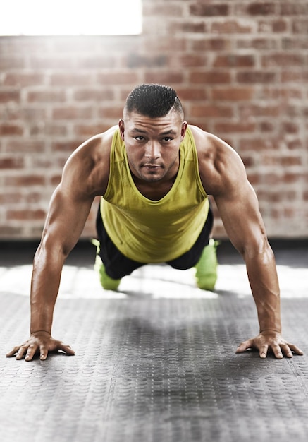 Muscle up Tir sur toute la longueur d'un jeune homme travaillant dans la salle de sport