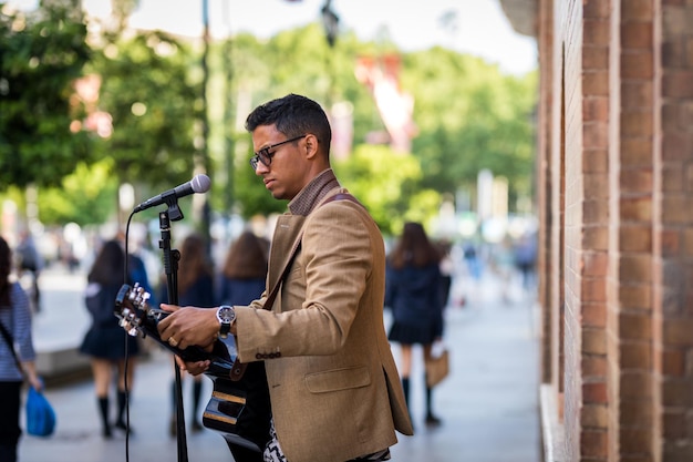 Musicien ambulant préparant sa guitare avant de jouer dans la rue